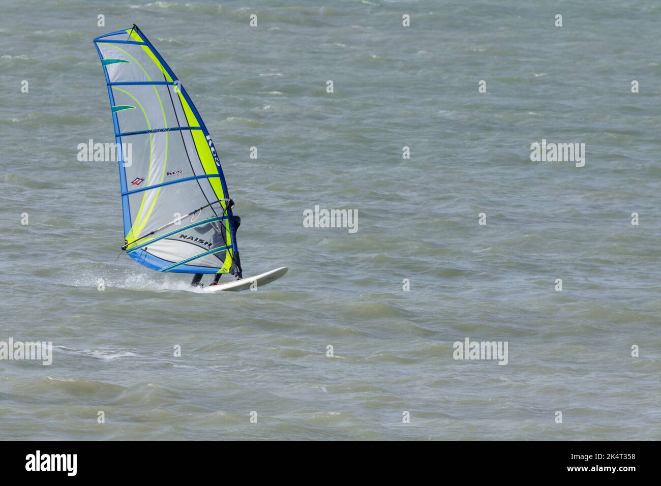 Sport acquatici windsurf in mare con vela per catturare il vento per spingere la tavola e il surfista vela è inclinato e girato per sterzare e catturare il vento Foto Stock