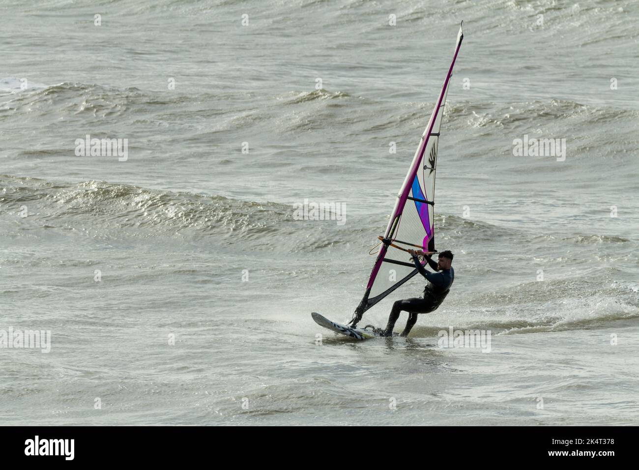 Sport acquatici windsurf in mare con vela per catturare il vento per spingere la tavola e il surfista vela è inclinato e girato per sterzare e catturare il vento Foto Stock