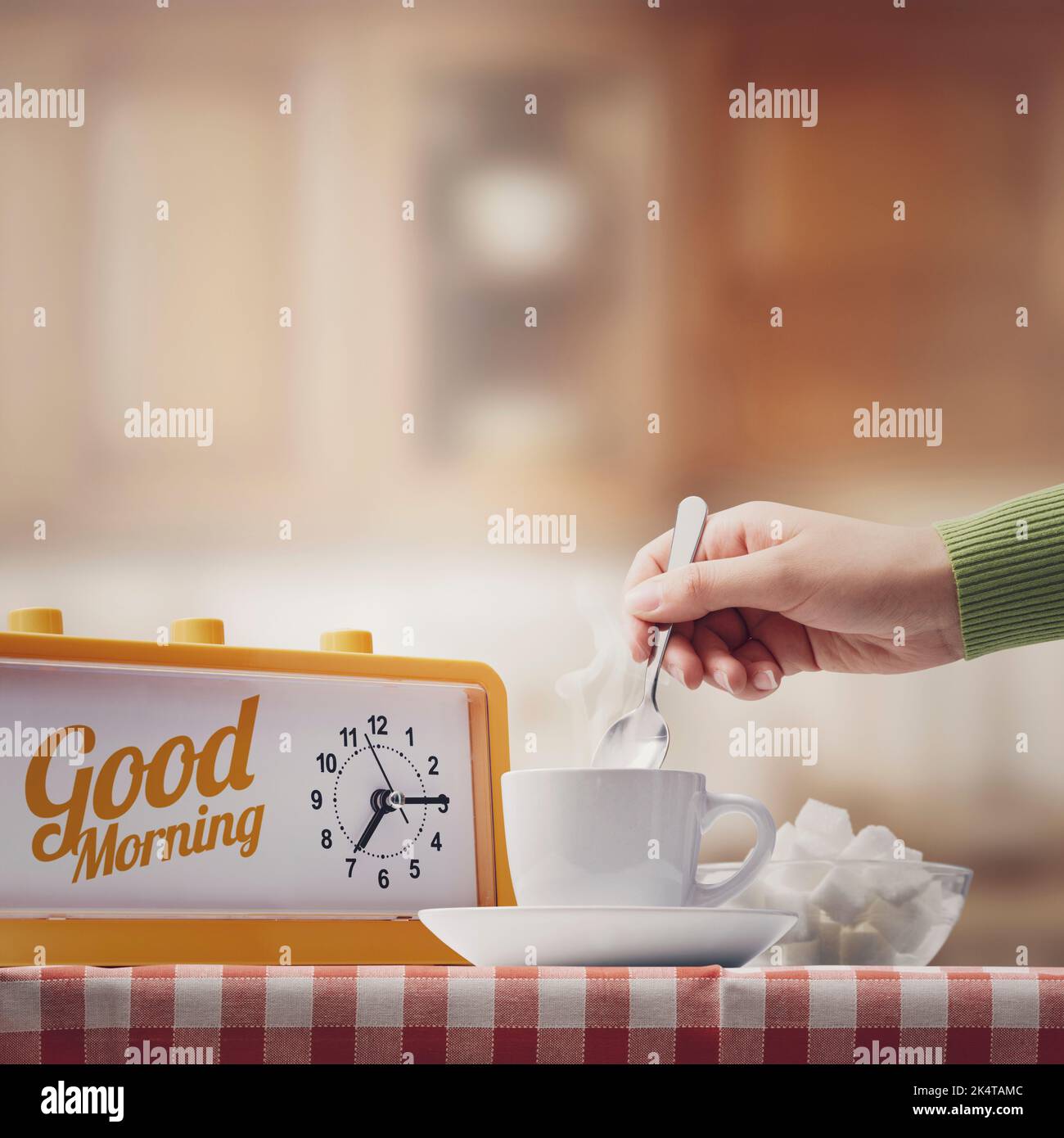 Donna che fa colazione a casa, lei sta mescolando caffè, mano primo piano Foto Stock
