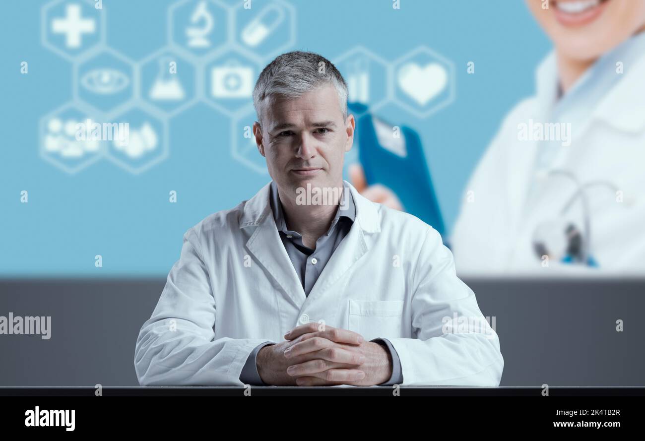 Scienziato medico che dà un discorso, icone mediche e schermo in background Foto Stock