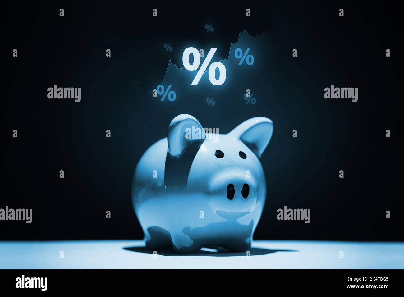 Il concetto di risparmio e investimento. Banco di piggy con un ologramma di grafici e percentuali. Foto Stock