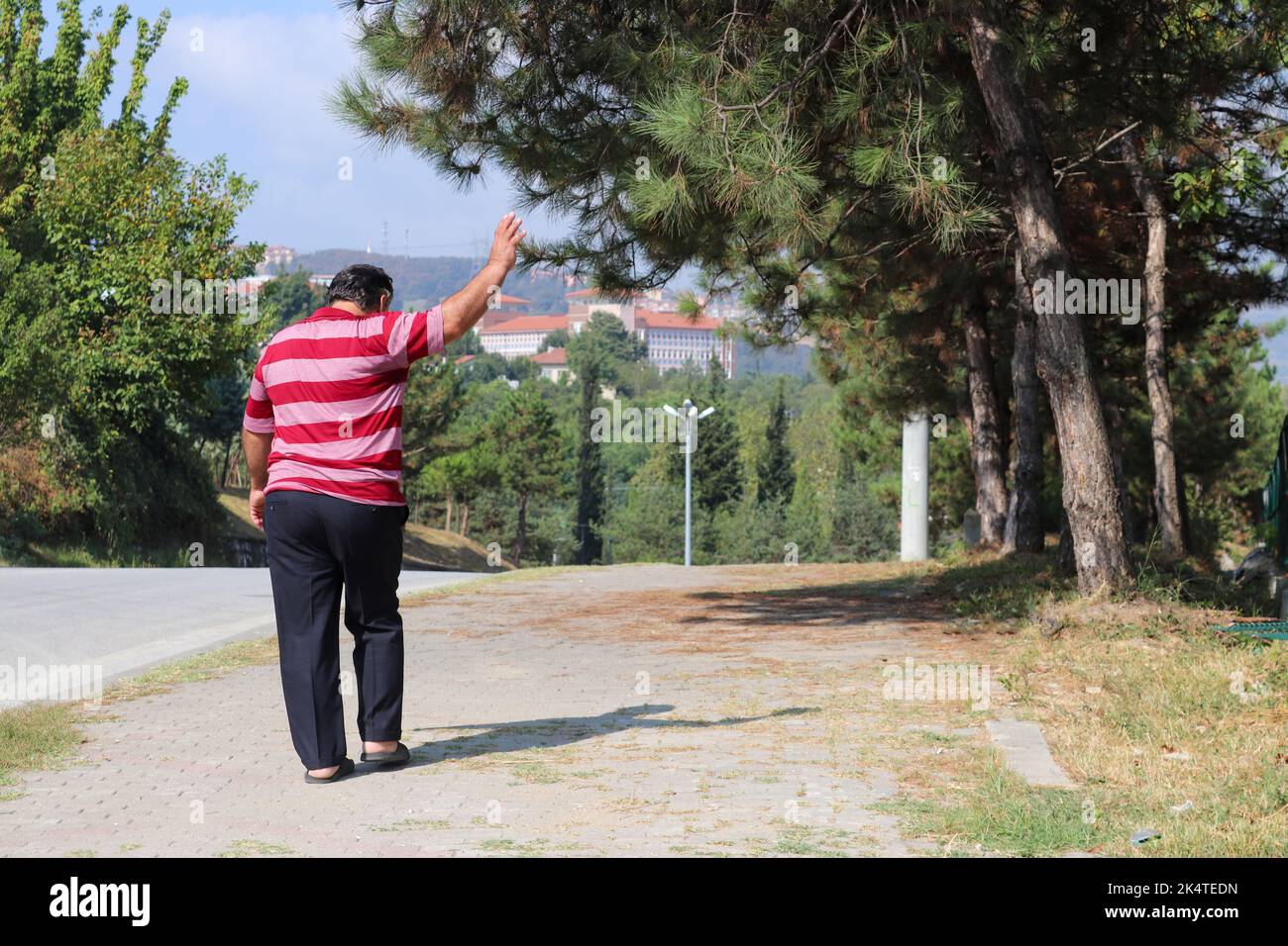 L'uomo che alza la mano per dire Arrivederci. L'uomo che disse Arrivederci e se ne andò. Il vecchio che cammina nelle pantofole. Foto Stock