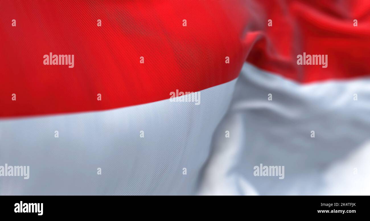 Vista ravvicinata della bandiera nazionale indonesiana che sventola nel vento. La Repubblica di Indonesia è uno Stato del Sud-est asiatico. Sfondo a trama di tessuto. S Foto Stock
