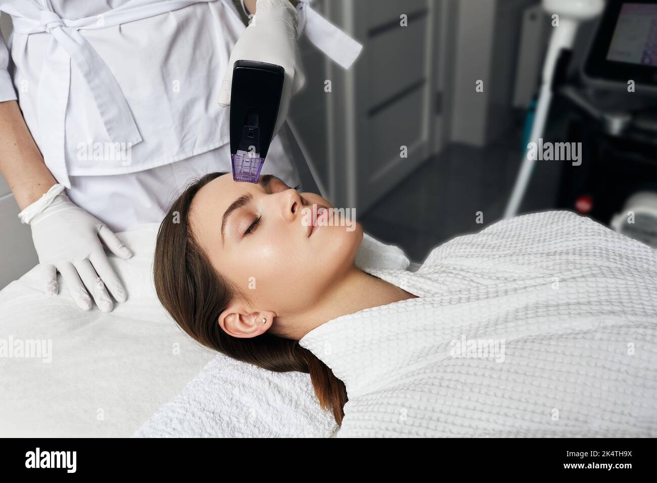 Effetto di sollevamento istantaneo e riduzione delle rughe per la pelle della fronte di una paziente donna dopo la procedura di sollevamento a radiofrequenza presso la clinica estetica di cosmetologia Foto Stock