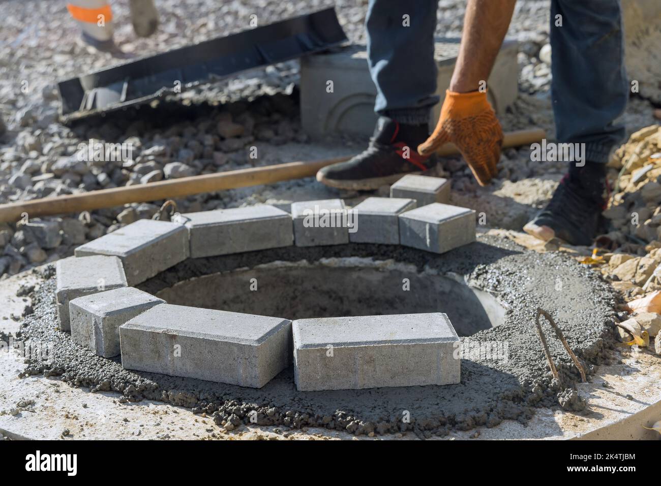 Costruzione di un tombino settico per la ricostruzione di fognature da parte di un operatore di servizi pubblici Foto Stock