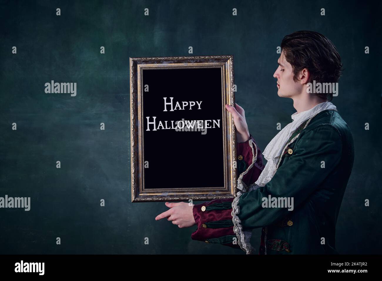 Ritratto dell'uomo in nobile costume medievale a immagine di vampiro con cornice isolata su sfondo verde scuro. Foto Stock
