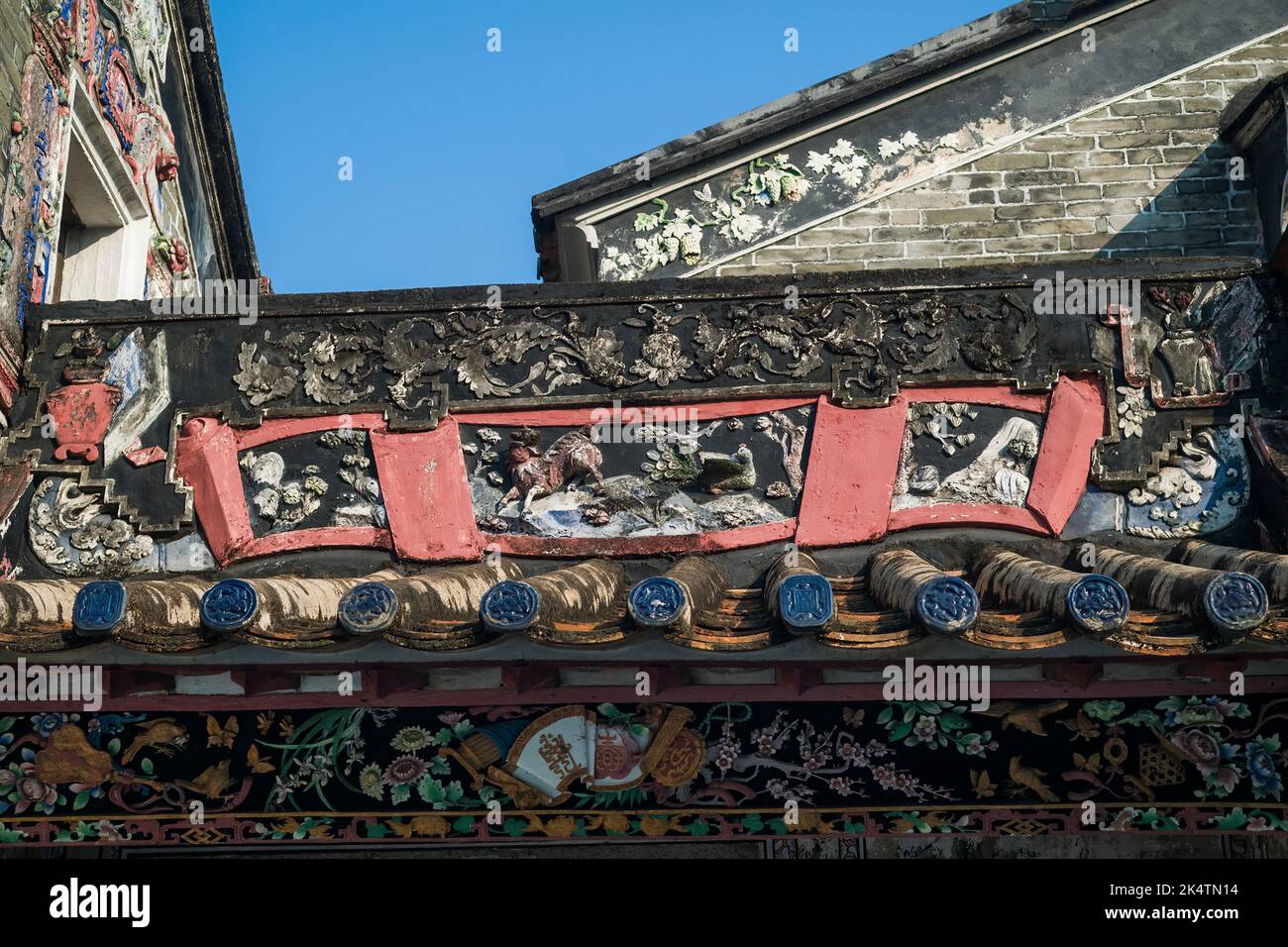 Particolare del fregio intagliato e dipinto sopra l'ingresso della pensione Ching Shu Hing adiacente alla sala di studio Kun Ting, entrambi costruiti nel 1870, in Foto Stock