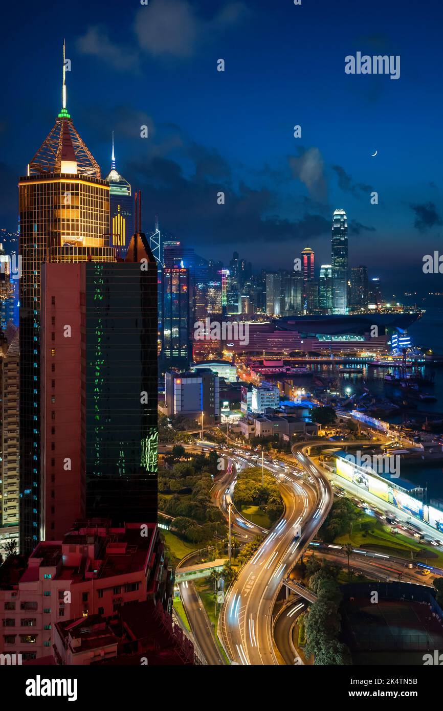 Gli alti edifici commerciali di Causeway Bay, WAN Chai e Central, Isola di Hong Kong, al crepuscolo con una luna nuova e sentieri leggeri da auto, 2011 Foto Stock