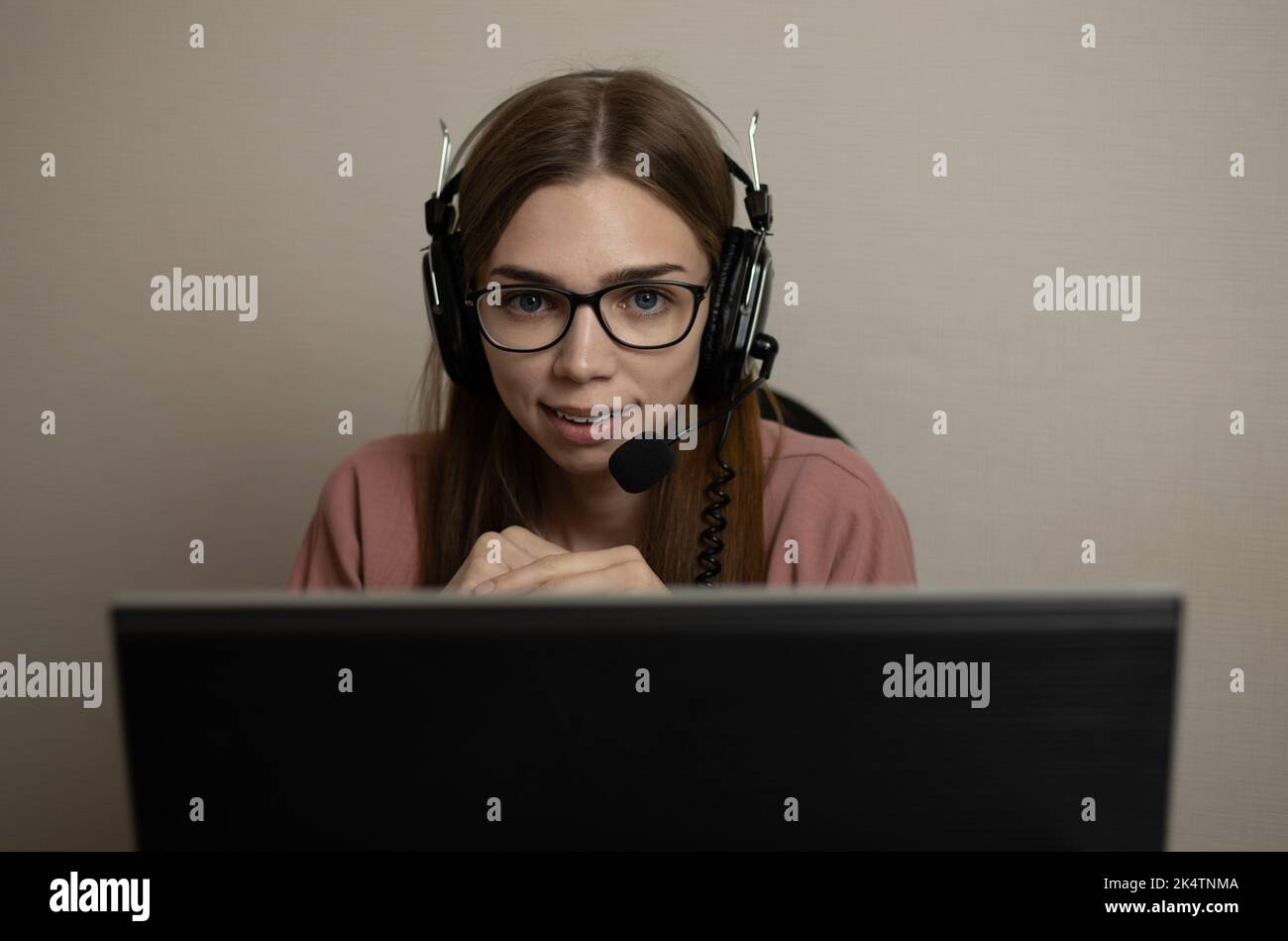 Un agente del call center soddisfatto che lavora su una hotline di assistenza in ufficio. L'operatore del call center sta parlando con il cliente. Primo piano. Un telemarketing, un Foto Stock