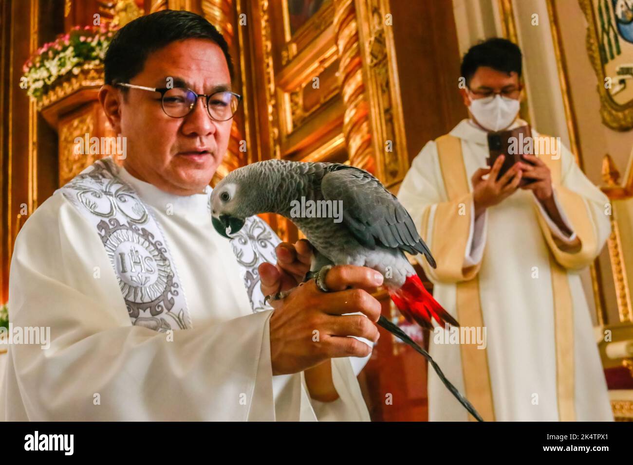 Antipolo, Filippine. 04th Ott 2022. Un prete imputrita il pappagallo prima della benedizione degli animali durante la Giornata Mondiale degli Animali. La Giornata Mondiale degli Animali è un evento annuale che si celebra ogni 4th ottobre, la festa di Francesco d'Assisi, patrono degli Animali. La celebrazione della Giornata Mondiale degli Animali mette in evidenza la protezione degli animali come la questione più importante in tutto il mondo. Credit: SOPA Images Limited/Alamy Live News Foto Stock