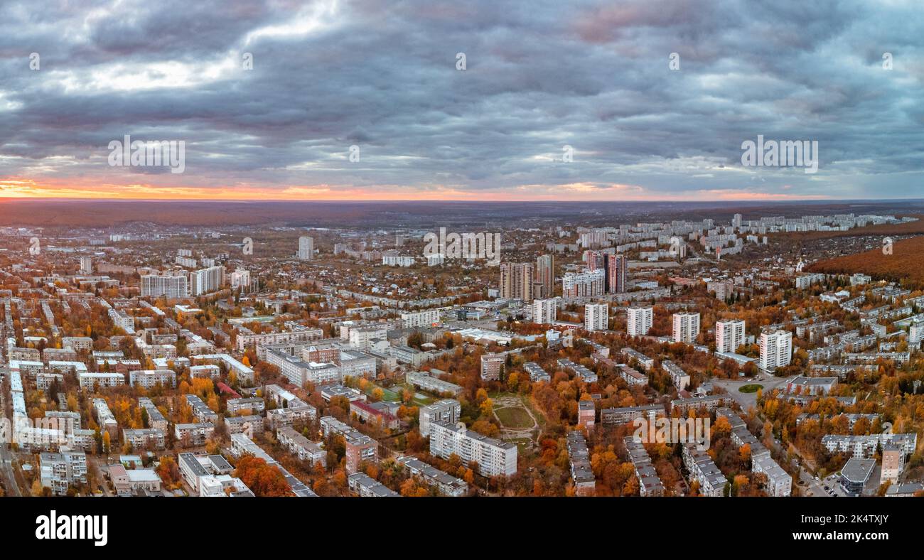 Vista aerea coloratissima del parco cittadino autunnale al tramonto con un paesaggio mozzafiato. Pavlovo Pole edifici residenziali quartiere alla luce della sera. Kharkiv, Ucraina Foto Stock