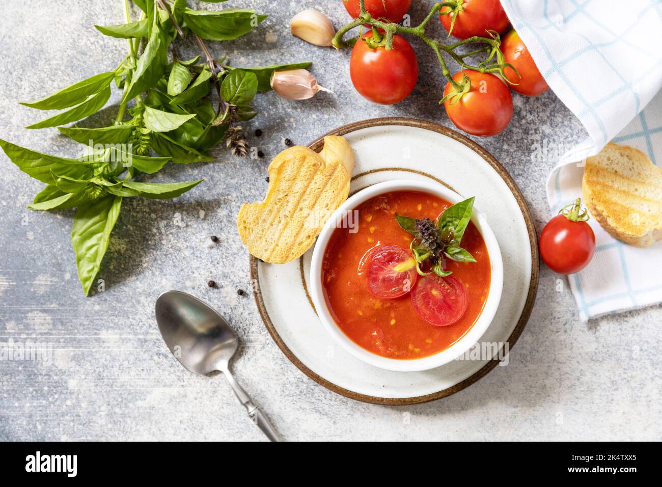 Dieta sana vegetariana. Zuppa vegana pomodori purè. Ciotola di zuppa di crema di pomodoro con basilico e crostini su un tavolo di pietra. Vista dall'alto. Foto Stock