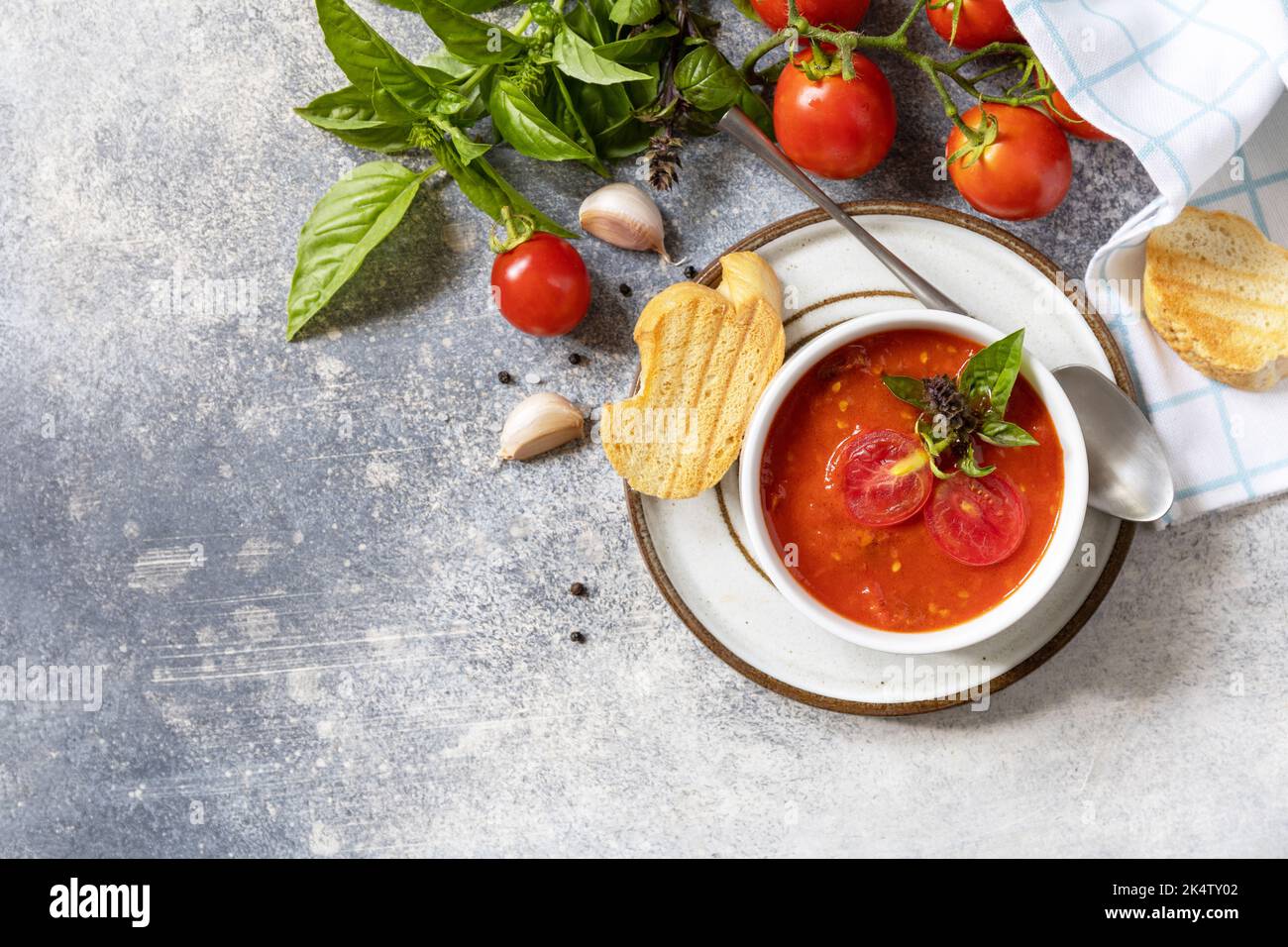 Dieta sana vegetariana. Zuppa vegana pomodori purè. Ciotola di zuppa di crema di pomodoro con basilico e crostini su un tavolo di pietra. Vista dall'alto. Spazio di copia. Foto Stock