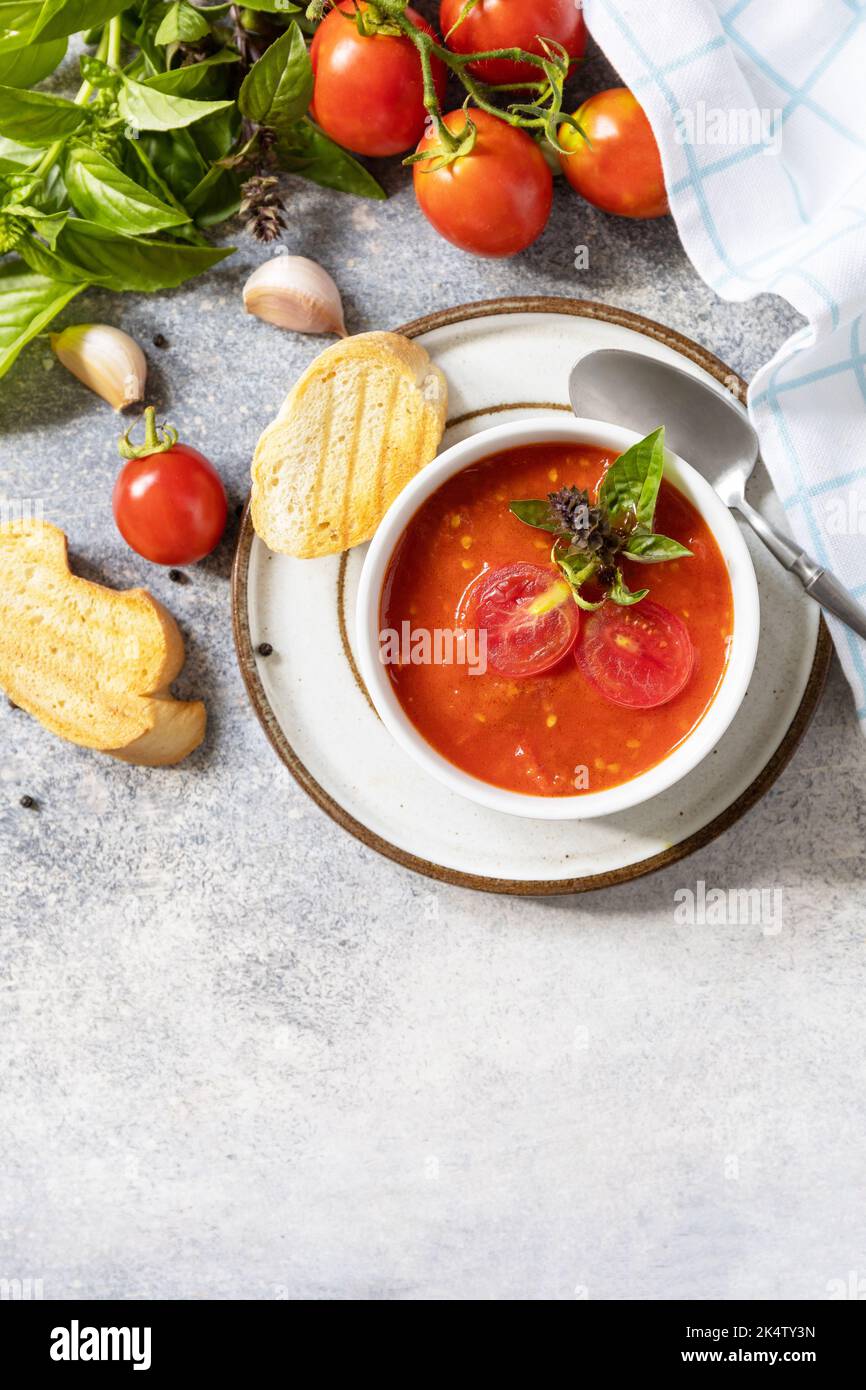 Dieta sana vegetariana. Zuppa vegana pomodori purè. Ciotola di zuppa di crema di pomodoro con basilico e crostini su un tavolo di pietra. Vista dall'alto. Spazio di copia. Foto Stock