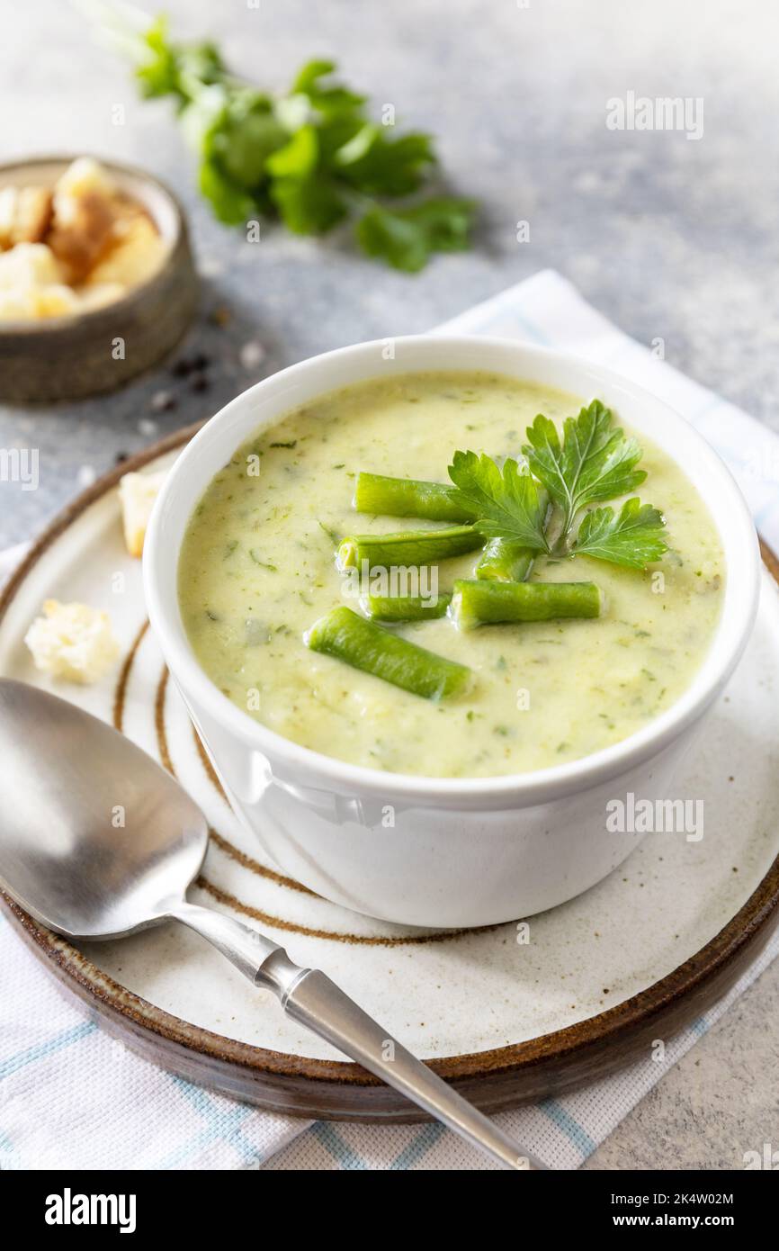 Cibo sano. Purea di verdure verdi per zuppa vegana. Ciotola di fagiolo verde e zuccini crema su un tavolo di pietra. Spazio di copia. Foto Stock