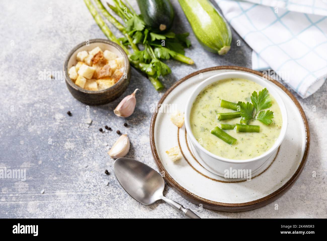 Purea di verdure verdi per zuppa vegana. Cibo sano. Ciotola di fagiolo verde e zuccini crema su un tavolo di pietra. Spazio di copia. Foto Stock