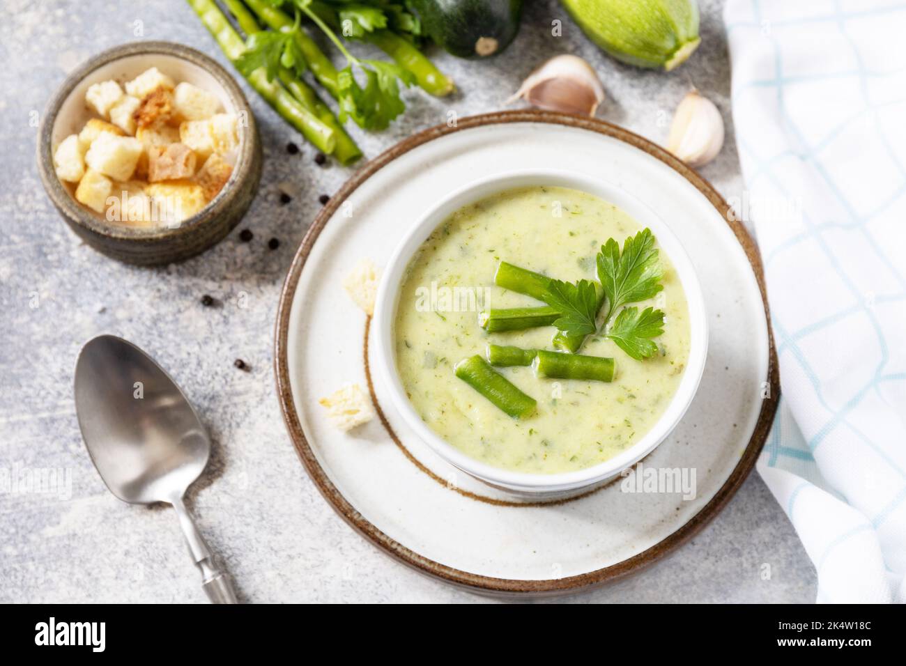 Purea di verdure verdi per zuppa vegana. Cibo sano. Ciotola di fagiolo verde e zuccini crema su un tavolo di pietra. Foto Stock
