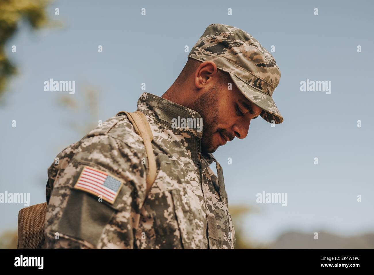 Un giovane soldato coraggioso che guarda giù mentre si trova fuori casa. Patriottico americano serviceman tornare a casa dopo aver servito il suo paese nel mili Foto Stock