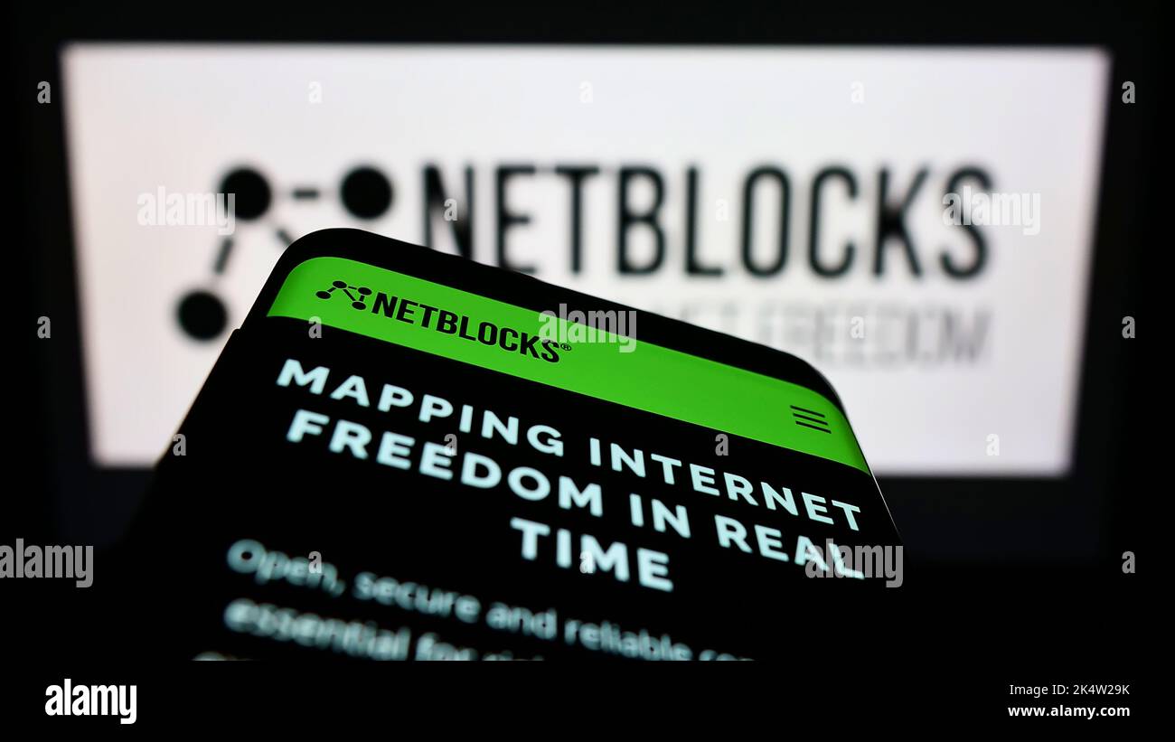 Telefono cellulare con sito web di Internet watchdog NetBlocks Ltd. Sullo schermo di fronte al logo. Messa a fuoco in alto a sinistra del display del telefono. Foto Stock