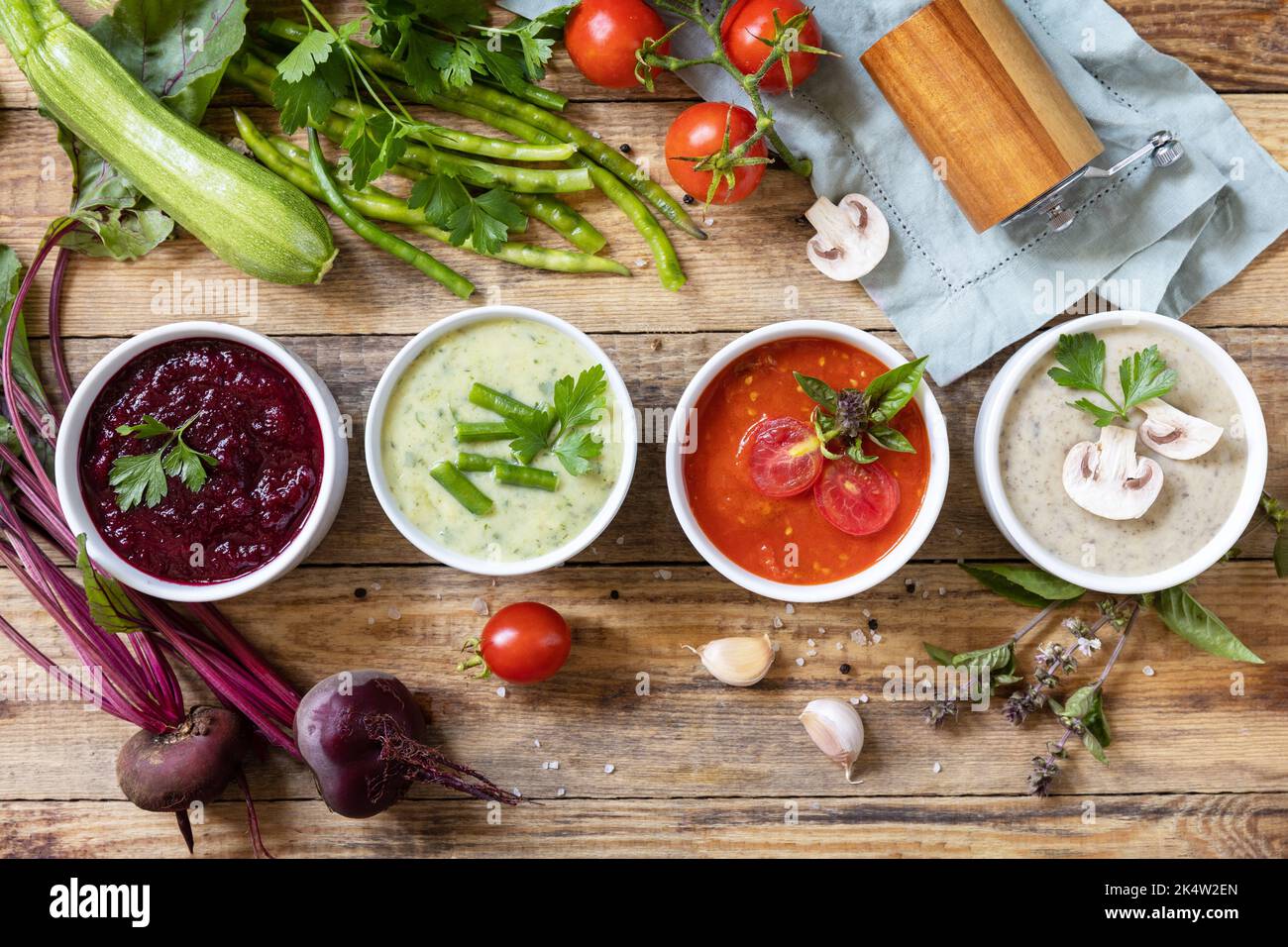 Set autunnale di diverse zuppe di verdure. Cibo sano. Zuppe di panna vegana (pomodori, funghi, barbabietole, fagiolini) su un tavolo di legno rustico. Visualizza fr Foto Stock
