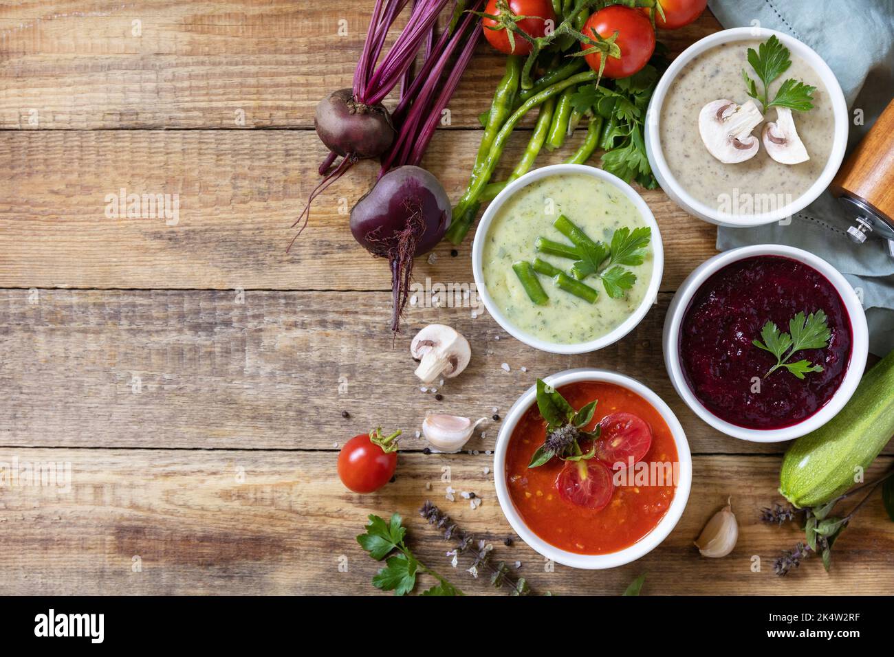 Set autunnale di diverse zuppe di verdure. Cibo sano. Zuppe di panna vegana (pomodori, funghi, barbabietole, fagiolini) su un tavolo di legno rustico. Visualizza fr Foto Stock