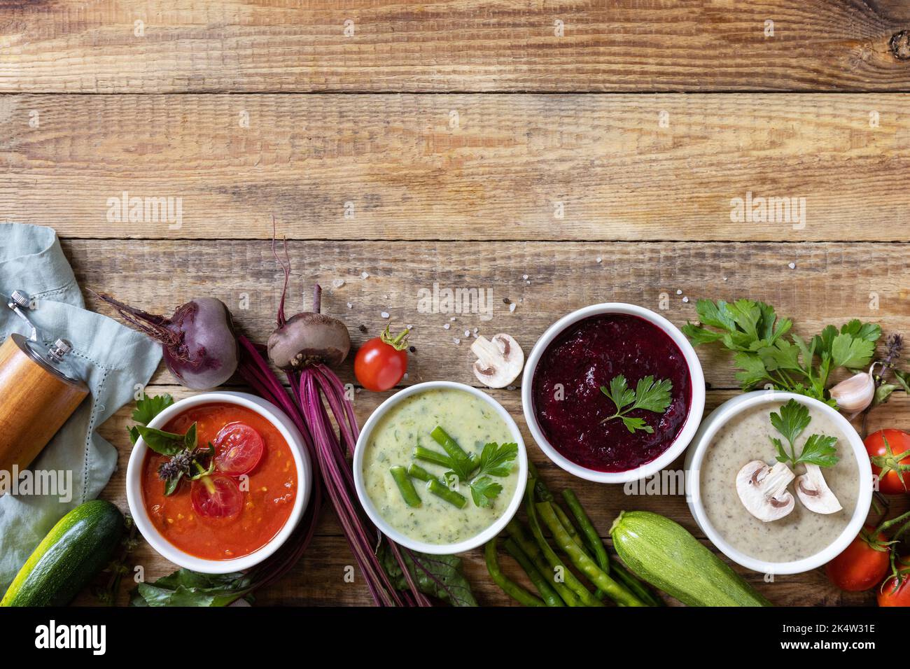 Set autunnale di diverse zuppe di verdure. Cibo sano. Zuppe di panna vegana (pomodori, funghi, barbabietole, fagiolini) su un tavolo di legno rustico. Visualizza fr Foto Stock