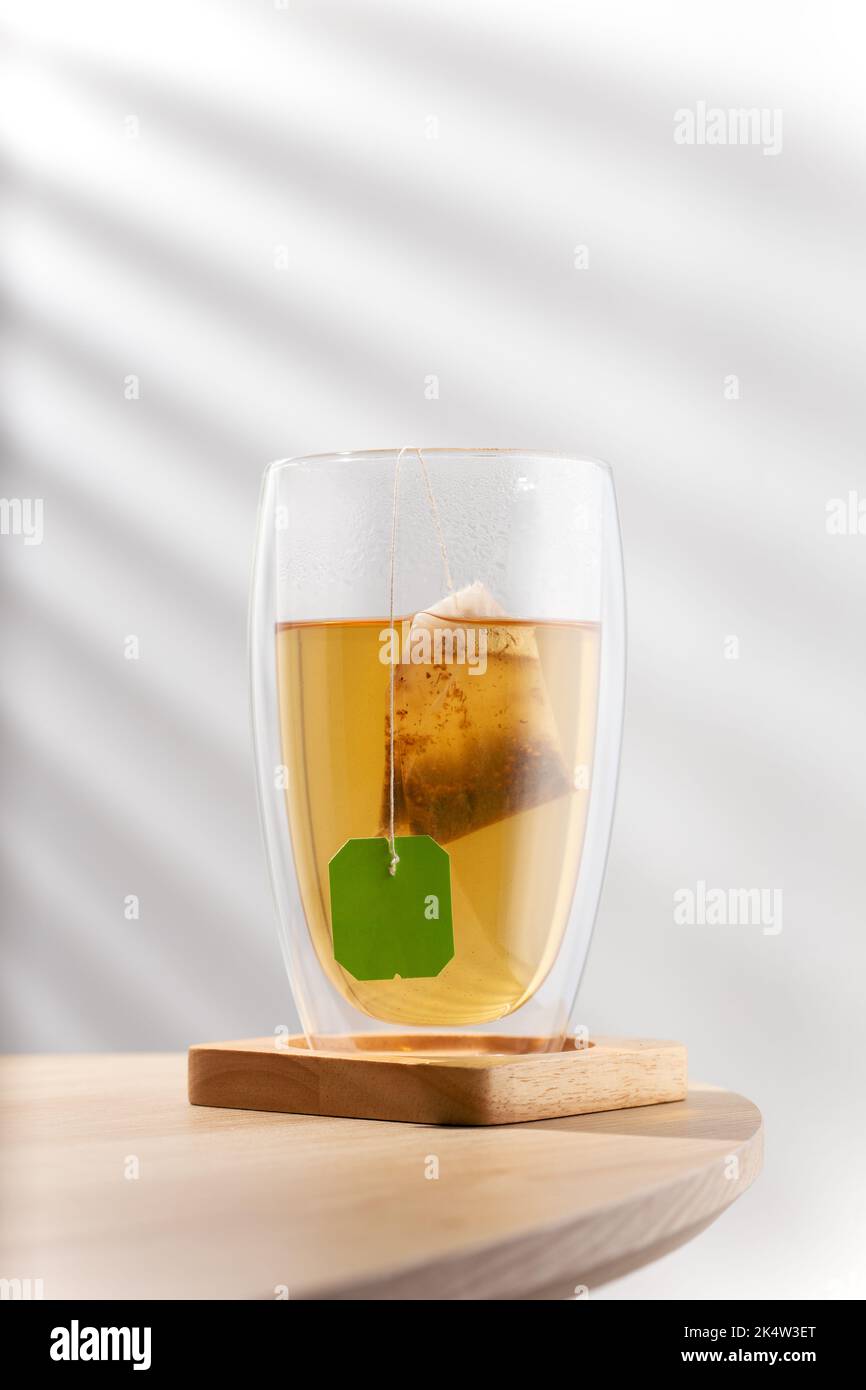 Tè caldo in un bicchiere termoresistente su un tavolo di legno Foto Stock