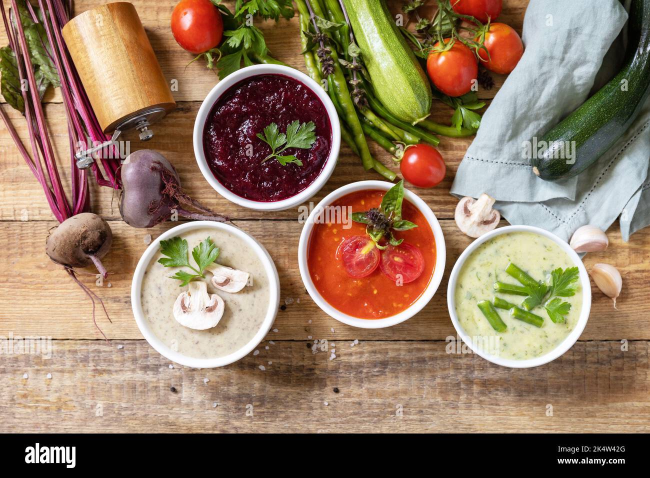 Cibo sano. Set autunnale di diverse zuppe di verdure. Zuppe di panna vegana (pomodori, funghi, barbabietole, fagiolini) su un tavolo di legno rustico. Visualizza fr Foto Stock