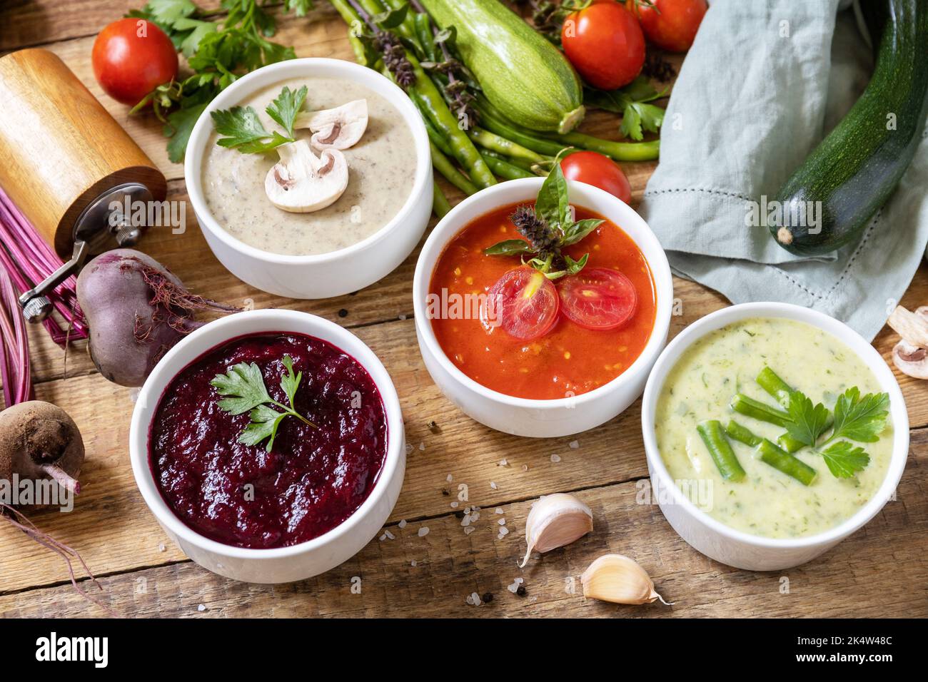 Set autunnale di diverse zuppe di verdure. Cibo sano. Zuppe di panna vegana (pomodori, funghi, barbabietole, fagiolini) su un tavolo di legno rustico. Foto Stock