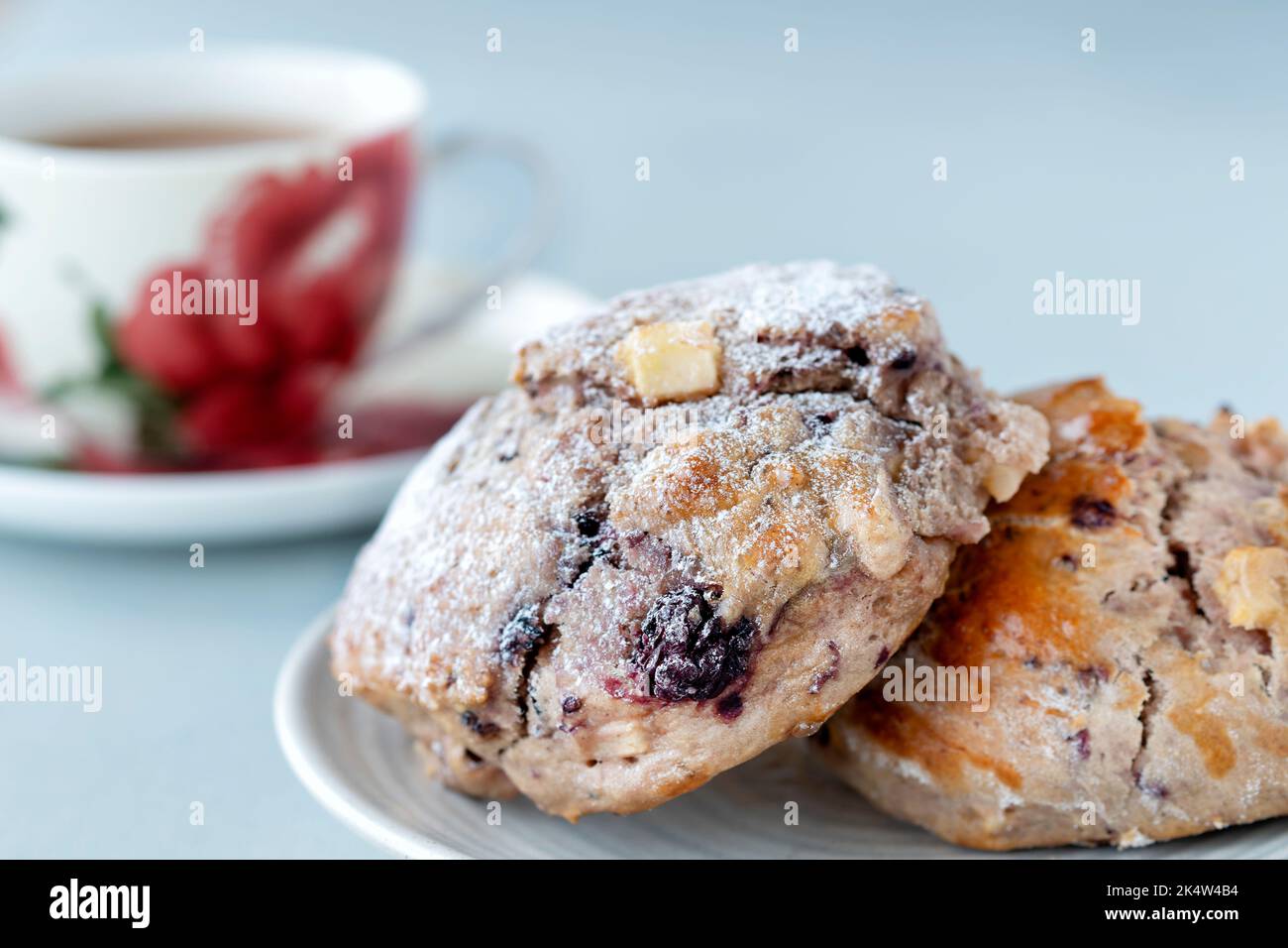 Freschi focaccine fatte in casa di mele e mora, serviti placcati con una tazza di tè in una tazza di porcellana. Cucinato da un libro di ricette di fiducia nazionale Foto Stock