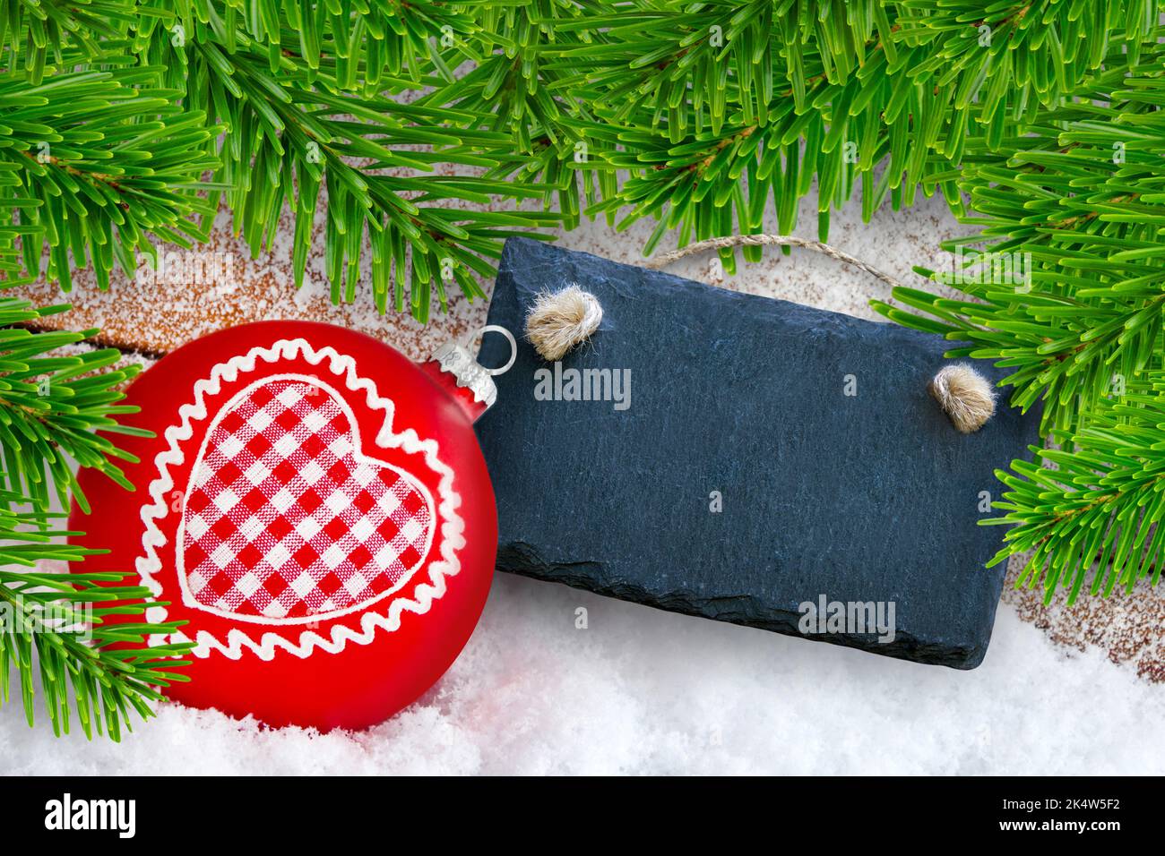 Decorazione natalizia con cuore, ornamento, etichetta, rami di neve e abete Foto Stock