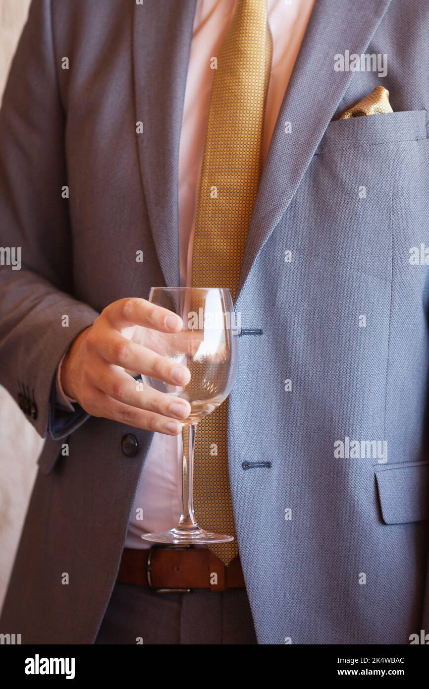Uomo in tuta con un bicchiere di vino vuoto Foto Stock