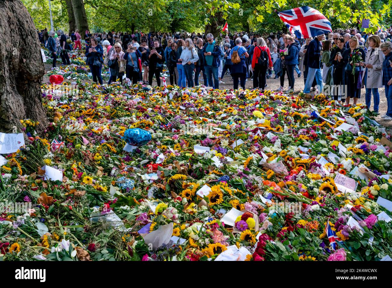 Gente britannica che guarda i tributi floreali per la regina Elisabetta II nel giardino tributo floreale a Green Park, Londra, Regno Unito Foto Stock