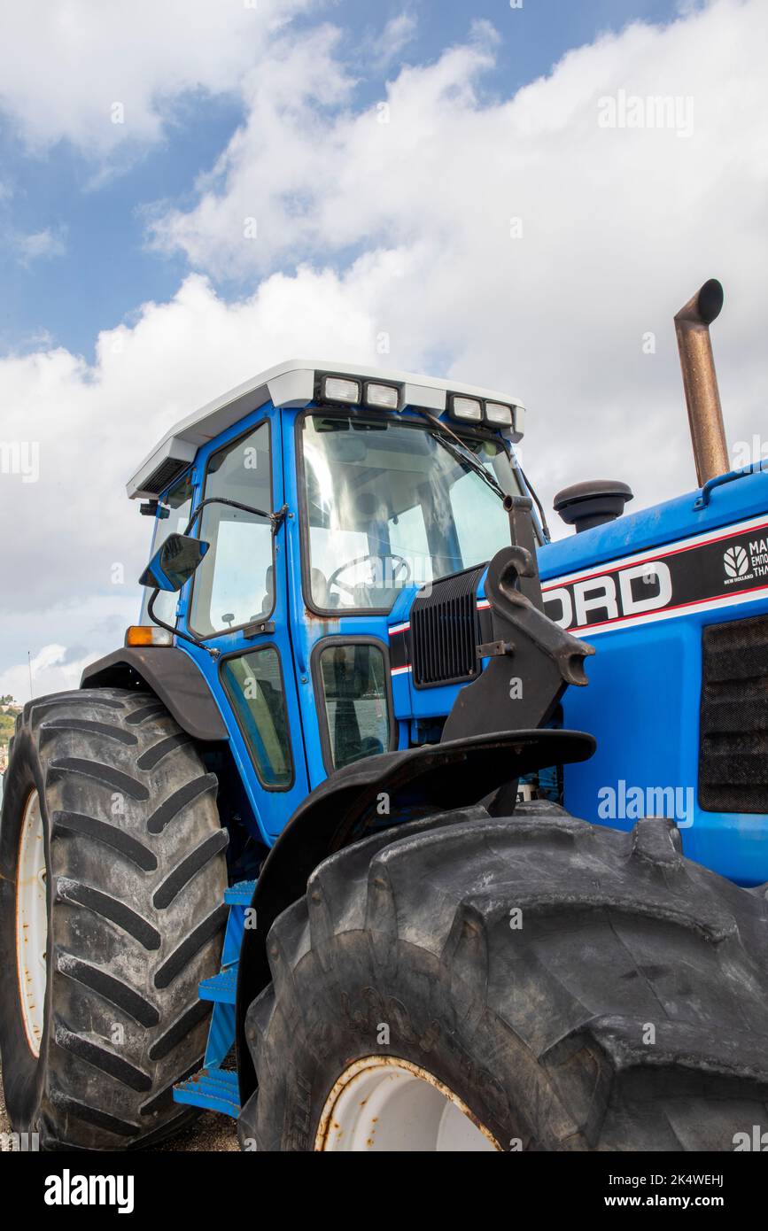 trattore ford con pneumatici grandi e cabina chiusa, macchinari agricoli moderni, trattore ford per macchinari agricoli, trattore ford grande e potente. Foto Stock