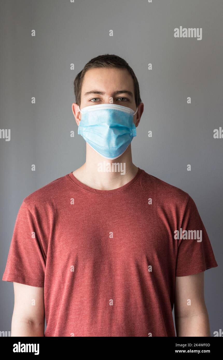 Primo piano ritratto di un uomo che indossa una maschera protettiva monouso Foto Stock