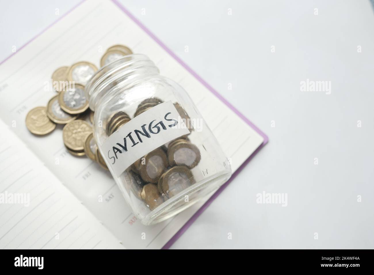 vasetto di risparmio monete e calcolatrice sul tavolo Foto Stock
