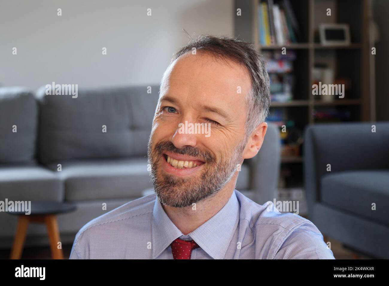 Uomo felice che si avvicina alla macchina fotografica. Uomo portatore che indossa una maglietta da lavoro. Uomo caucasico adulto di 30s o 40s anni. Foto Stock