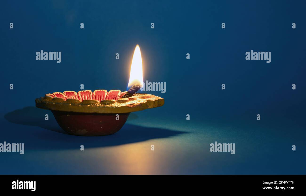 Diwali, Deepavali Hindu Festival di luci celebrazione. Spia dell'olio DIYA accesa su sfondo blu. Modello di vacanza indiano Foto Stock