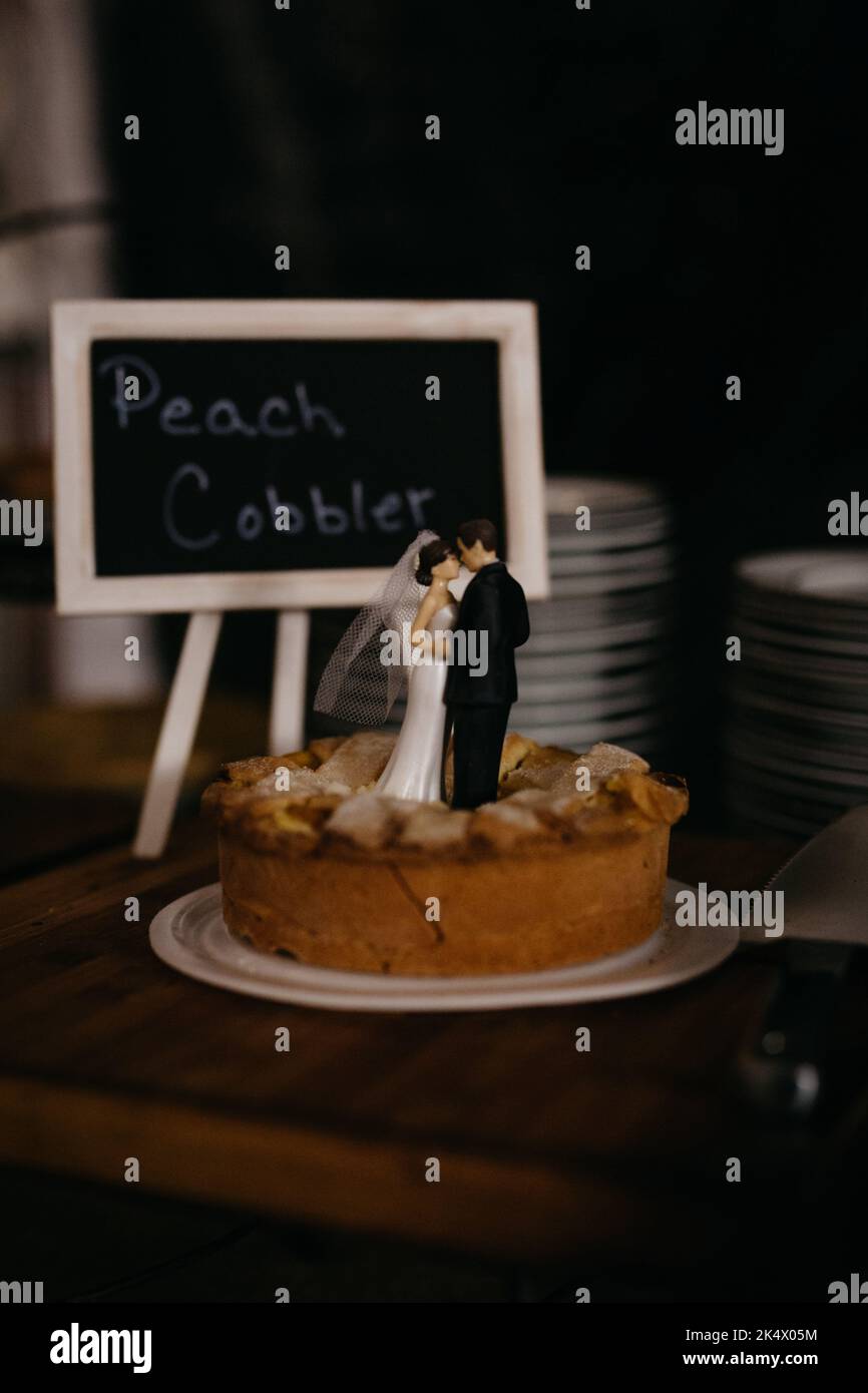 Acciottolato di pesche con figure di sposa e sposo in cima Foto Stock