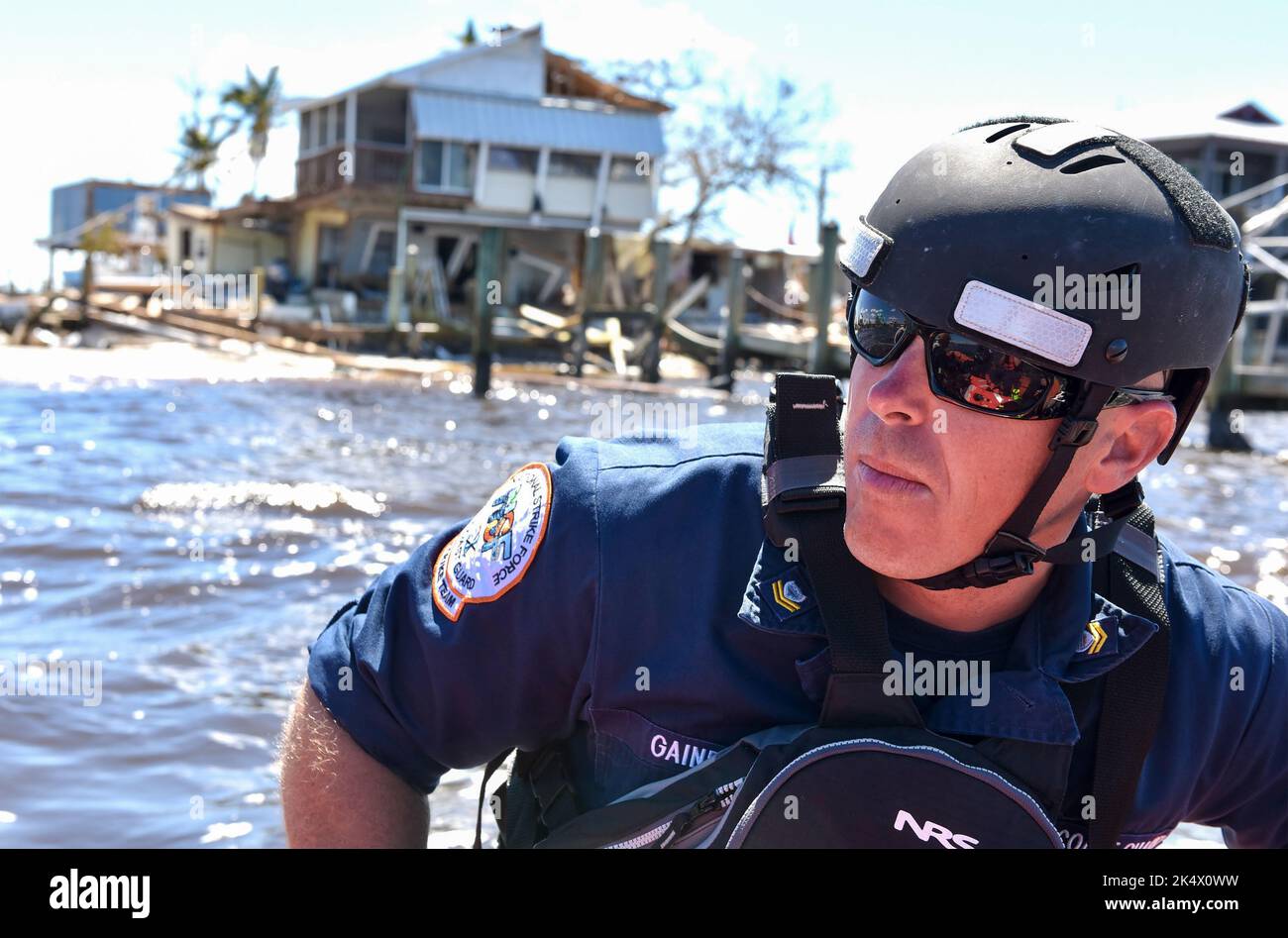 Dopo l'uragano Ian, Hunter Gaines, assegnato alla Gulf Strike Team della Guardia Costiera degli Stati Uniti, transita le acque al largo di Matlacha, Florida, il 2 ottobre 2022. La Guardia Costiera ha lavorato con agenzie statali e locali, oltre a buoni samaritani, per garantire che i residenti di Pine Island avessero il trasporto verso la terraferma e l'accesso ad acqua pulita e cibo in seguito all'uragano. Foto Stock