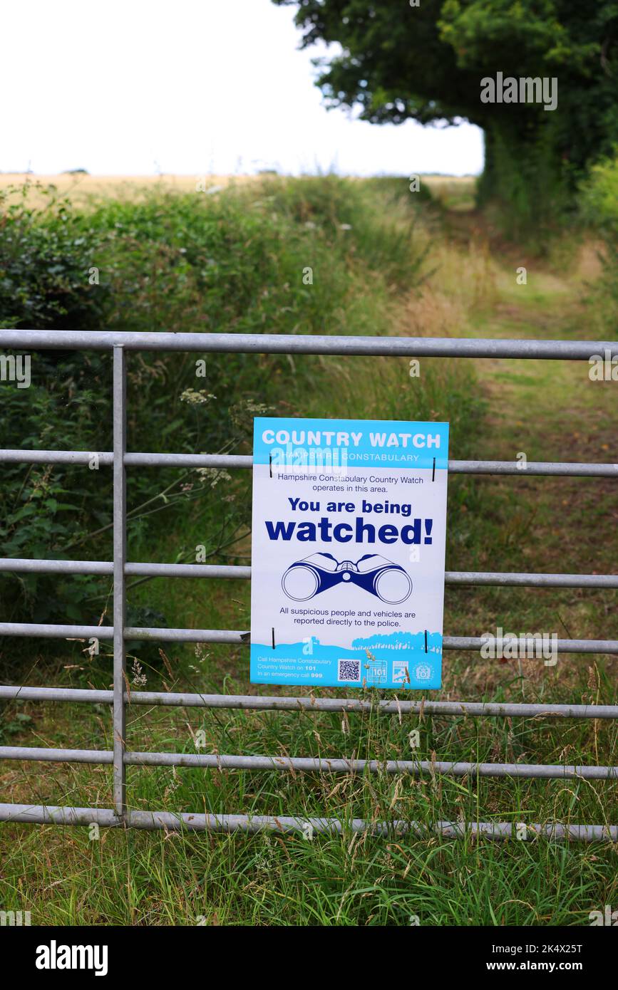 Un cartello di Country Watch "You are being watched" (ti stai osservando) su un cancello di una fattoria nell'Hampshire, Regno Unito. Foto Stock