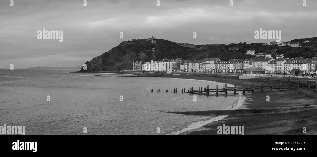 Una panoramica del mare con il ponte in acqua e gli edifici vicino alla spiaggia Foto Stock