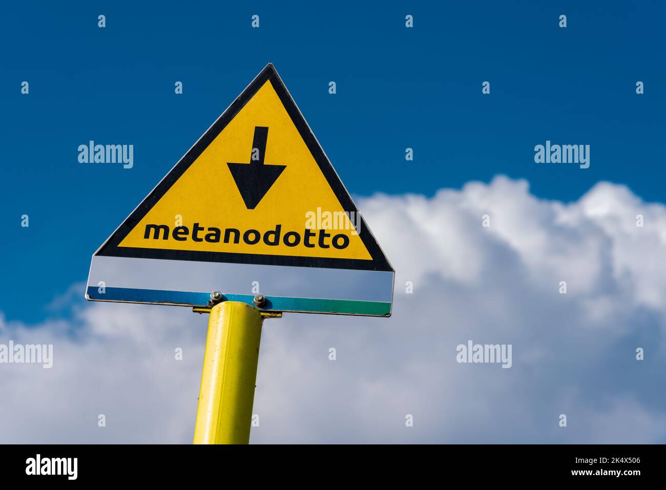 Cartello con indicazione della presenza del metanodotto sotterraneo in Italia, cartello metanodotto su cielo blu e nuvola Foto Stock
