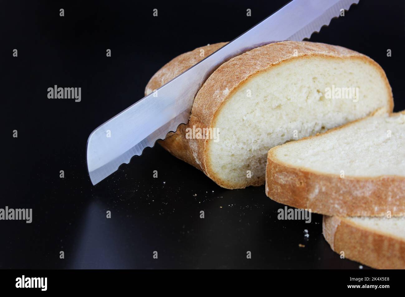 Coltello per il pane tagliato fresco, croccante, pane di segale. Affettare del pane delizioso Foto Stock