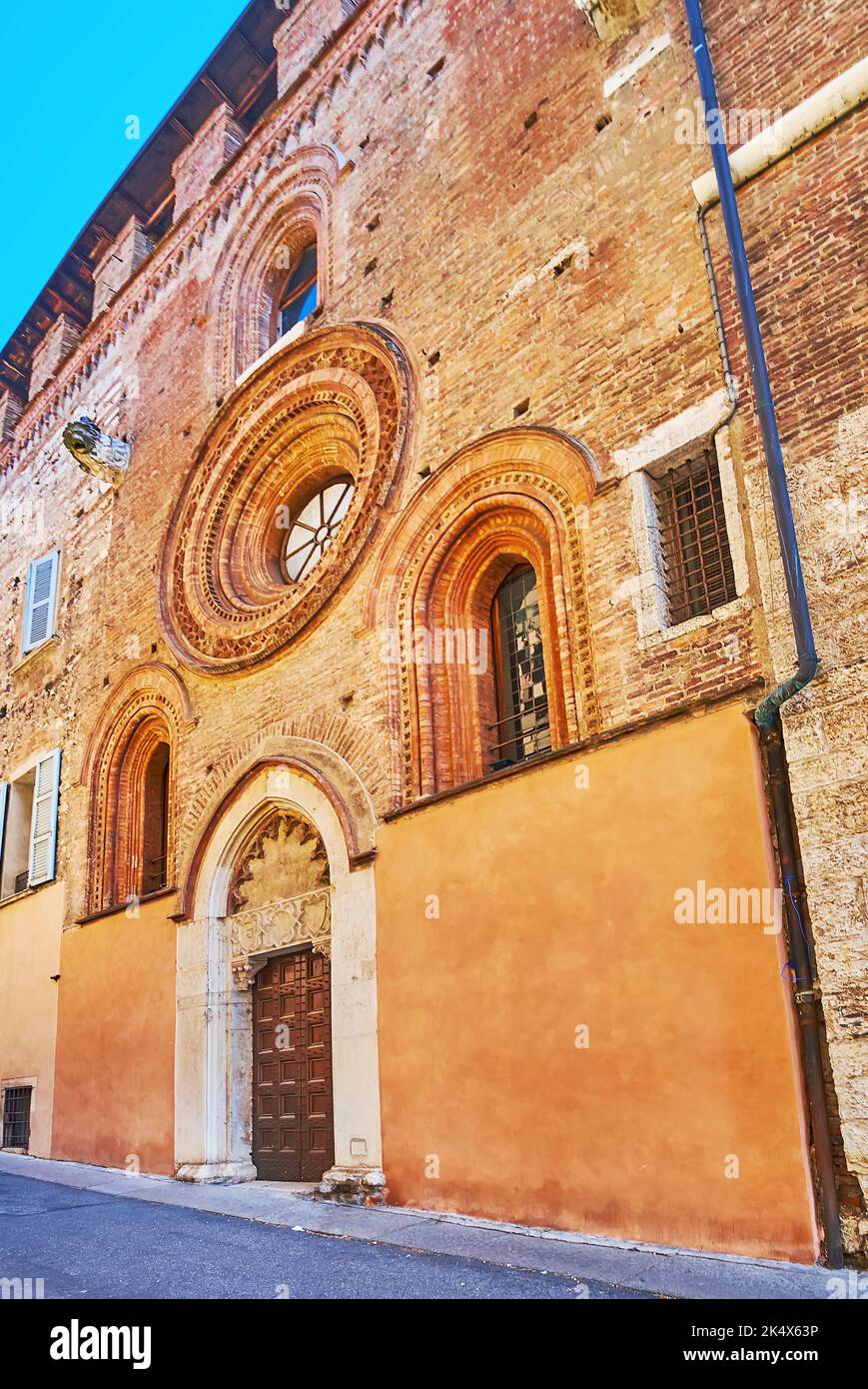 La facciata in mattoni medioevali della Chiesa di Sant'Agostino con porte ornamentali e infissi, Brescia, Lombardia, Italia Foto Stock