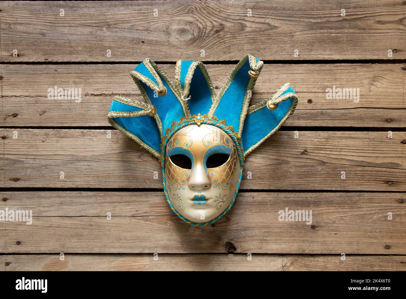 Maschera veneziana si trova su un tavolo di legno, maschera teatrale vintage Foto Stock