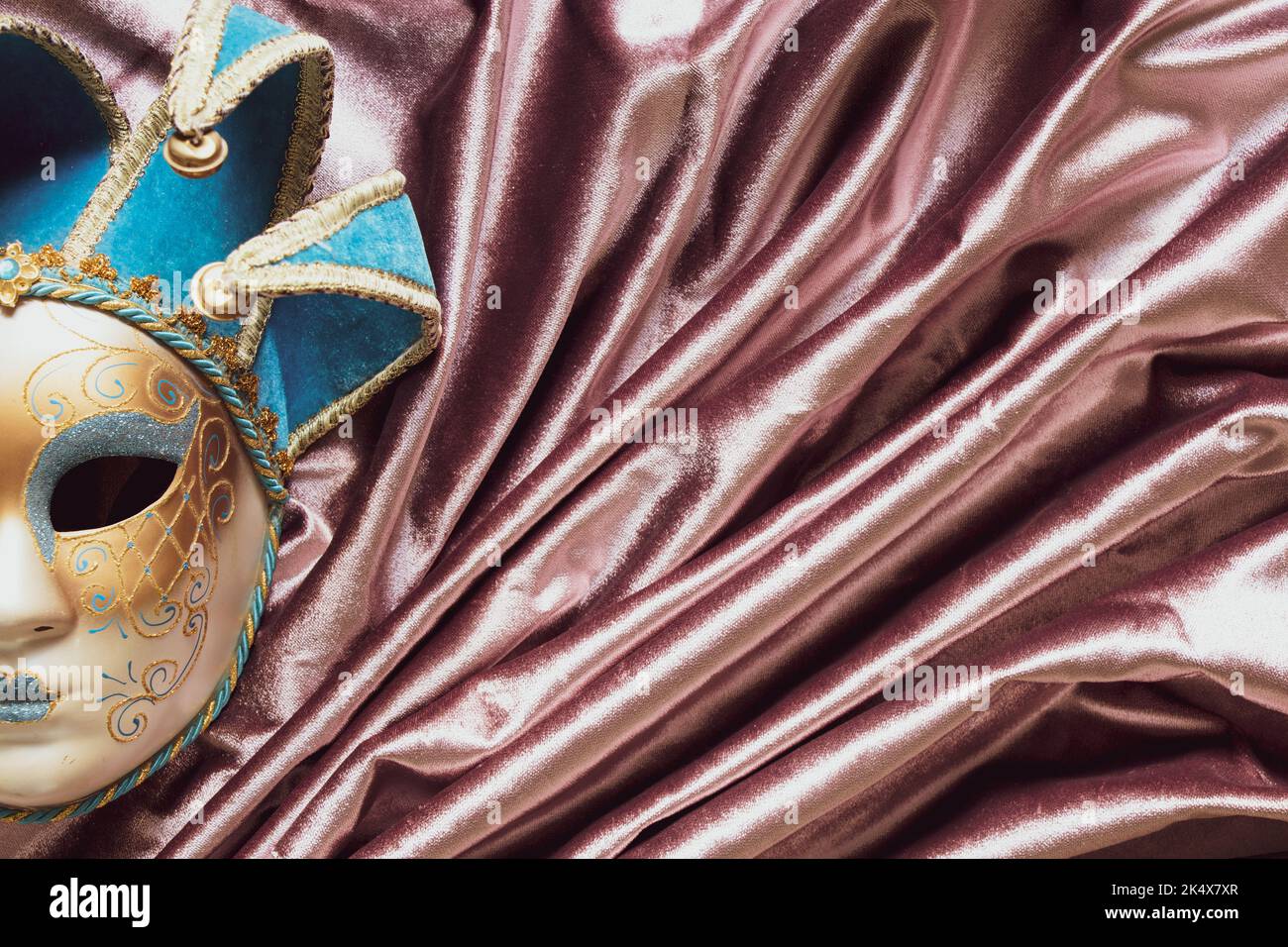 Maschera veneziana su tessuto rosa seta, maschera teatrale vintage Foto Stock