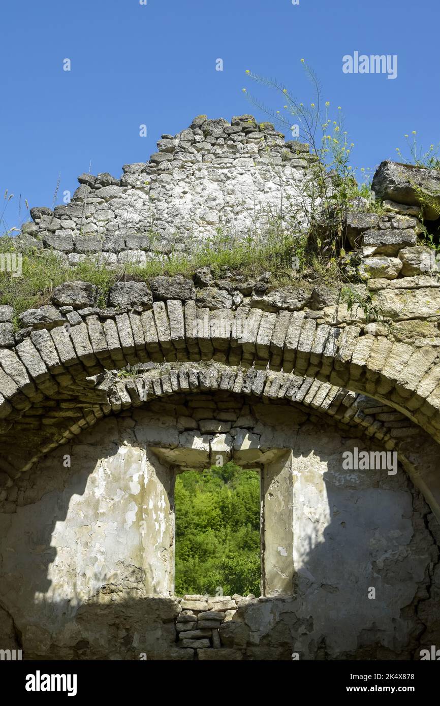 Rovine di un antico tempio cristiano contro il cielo blu. Soffitto crollato. Muratura, sala con volte ad arco. L'erba cresce sulle pareti. Rashkov, Moldavia. Cl Foto Stock