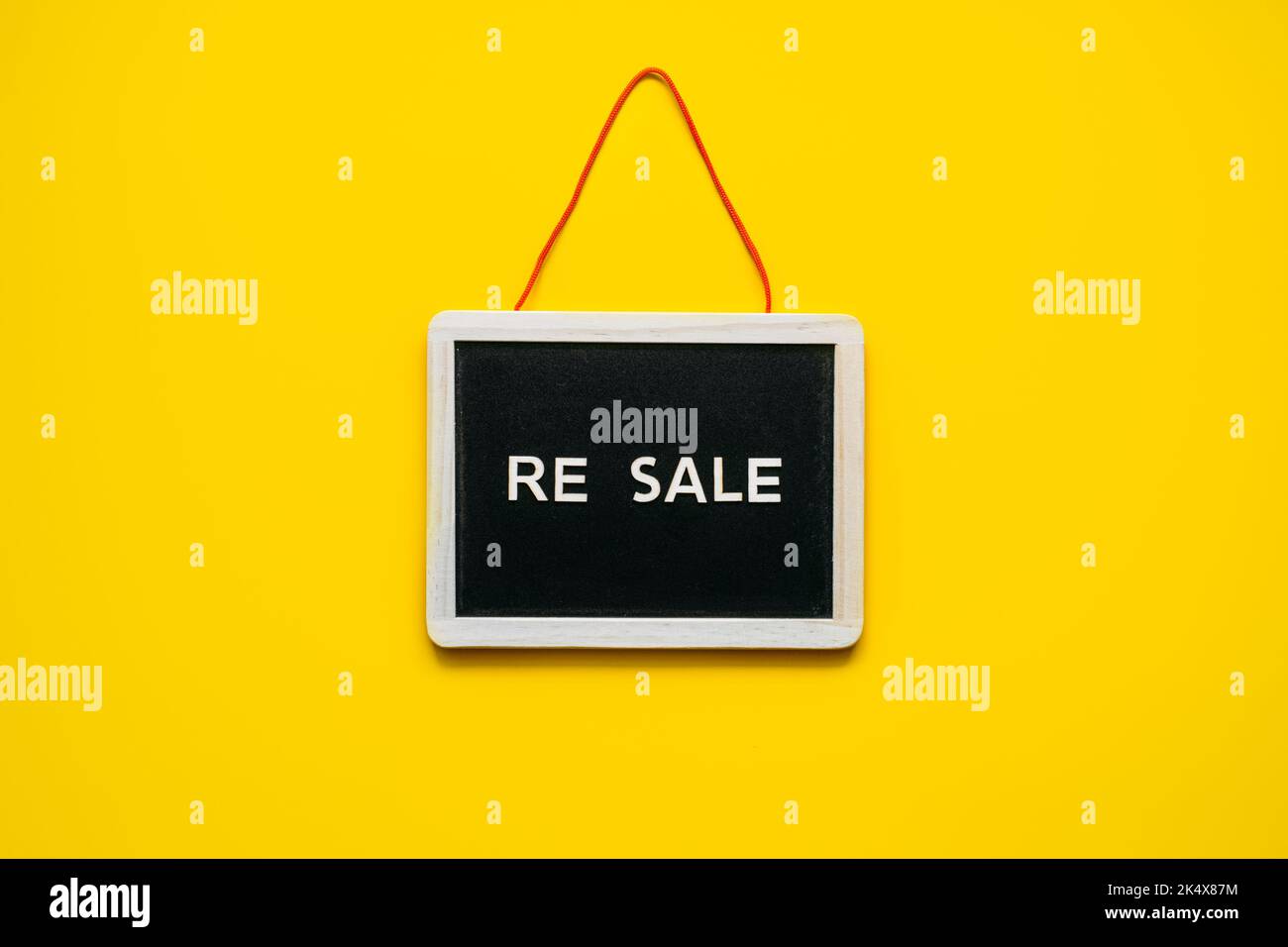 Concetto di rivendita-commercio, re-commercio, re-vendita. Buyback, permuta e Upcycling nel retail. Economia circolare. Rivendita parola e abbigliamento su giallo Foto Stock