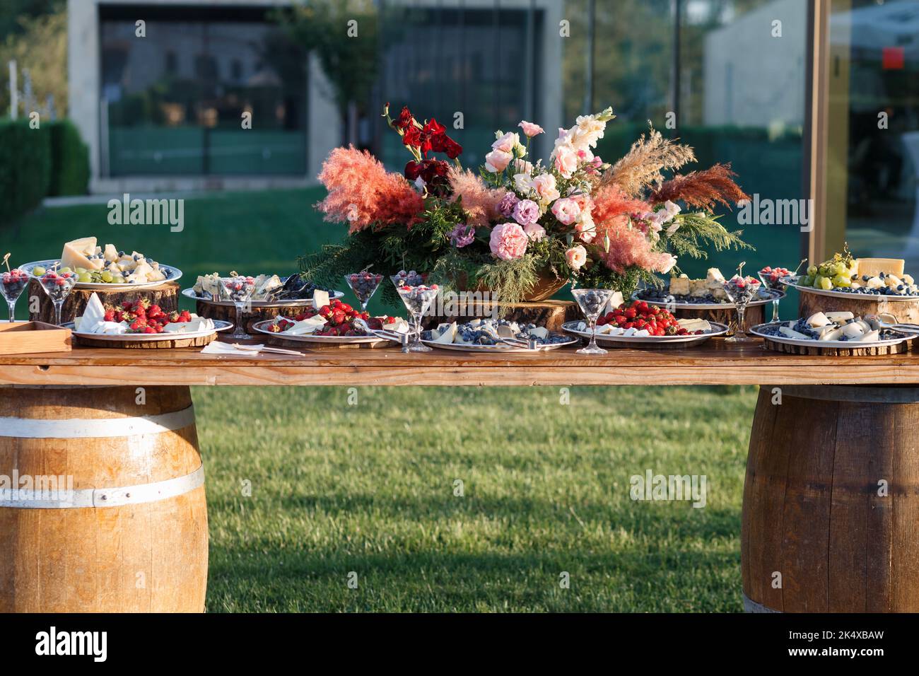 Assortimento di formaggi, frutti di bosco, frutta sulla tavola all'aperto. Vista frontale. Foto Stock